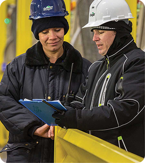Man in a hard hat talking with a woman in a hard hat