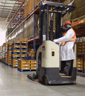 Man driving forklift in white coat
